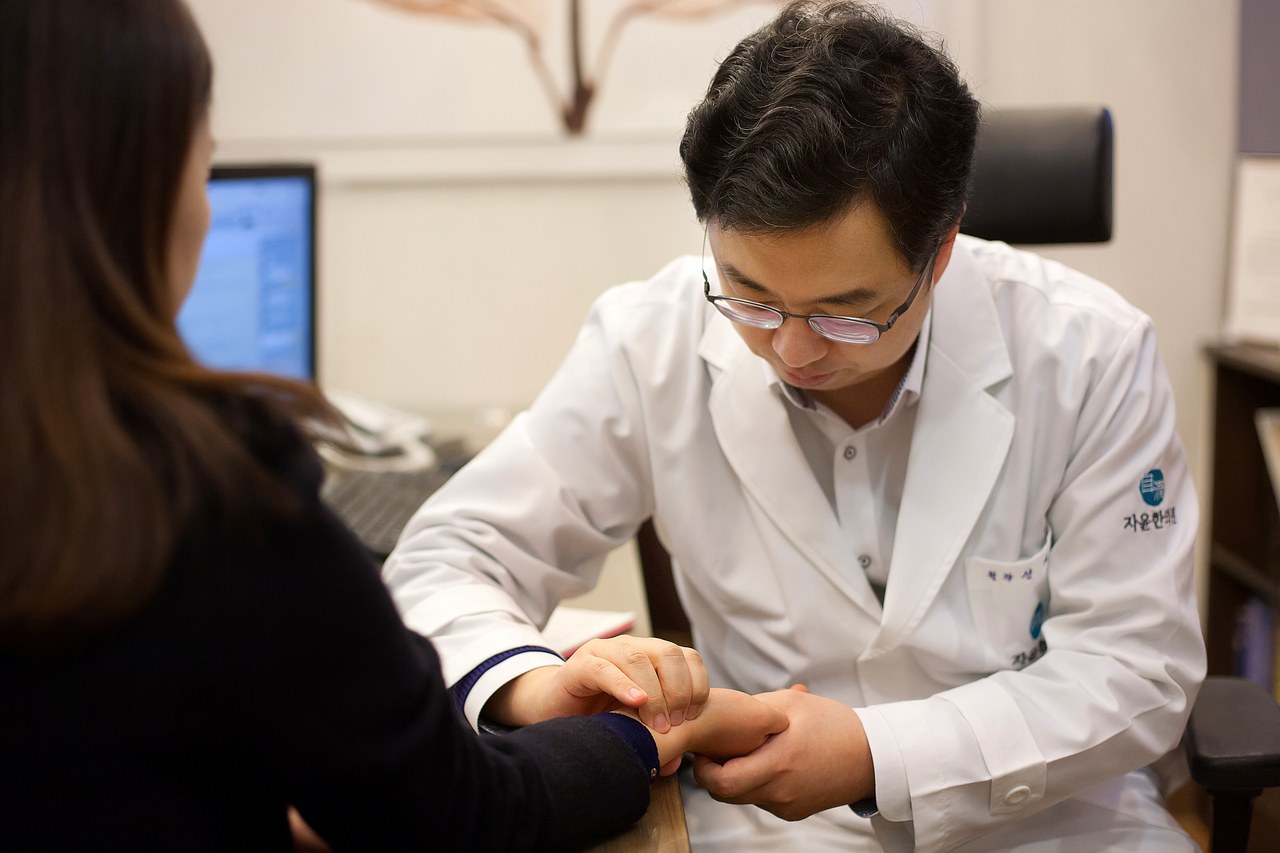 부천 다낭성난소증후군 &ndash; 여성 환자의 손목을 짚어 맥을 보는 한의사